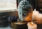 Cabeça de Buda, velas acesas e cristal roxo.