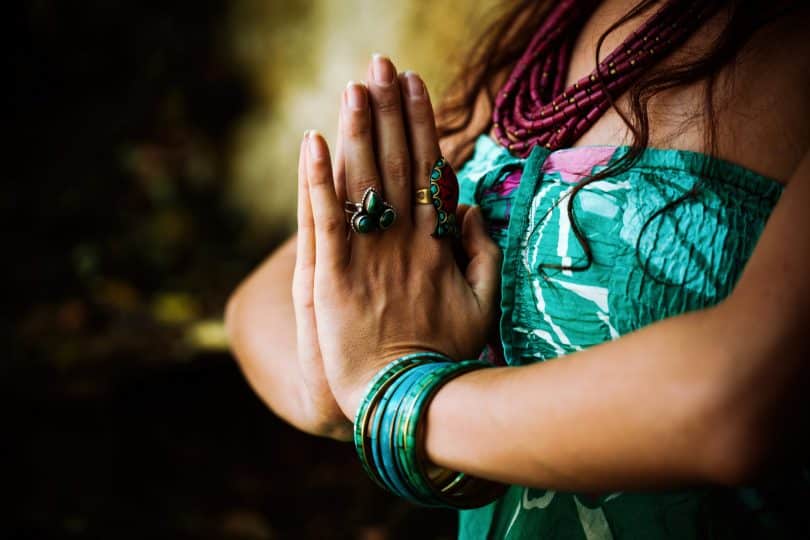 Mulher praticando o gesto do namaskara mudra.