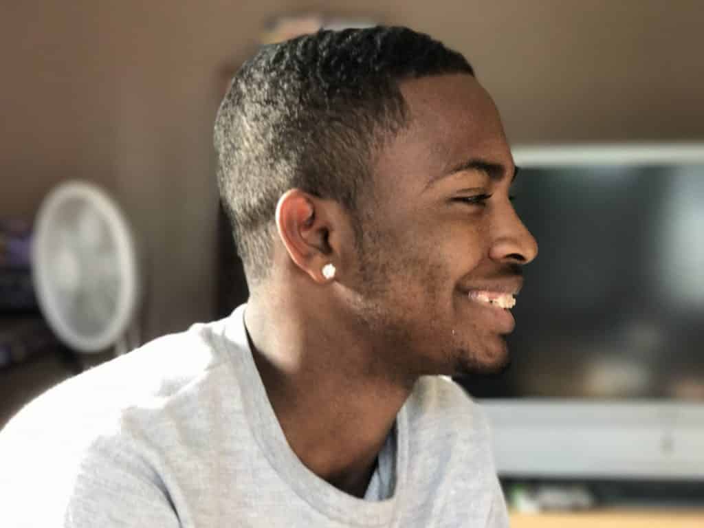 Perfil de homem negro sorrindo.