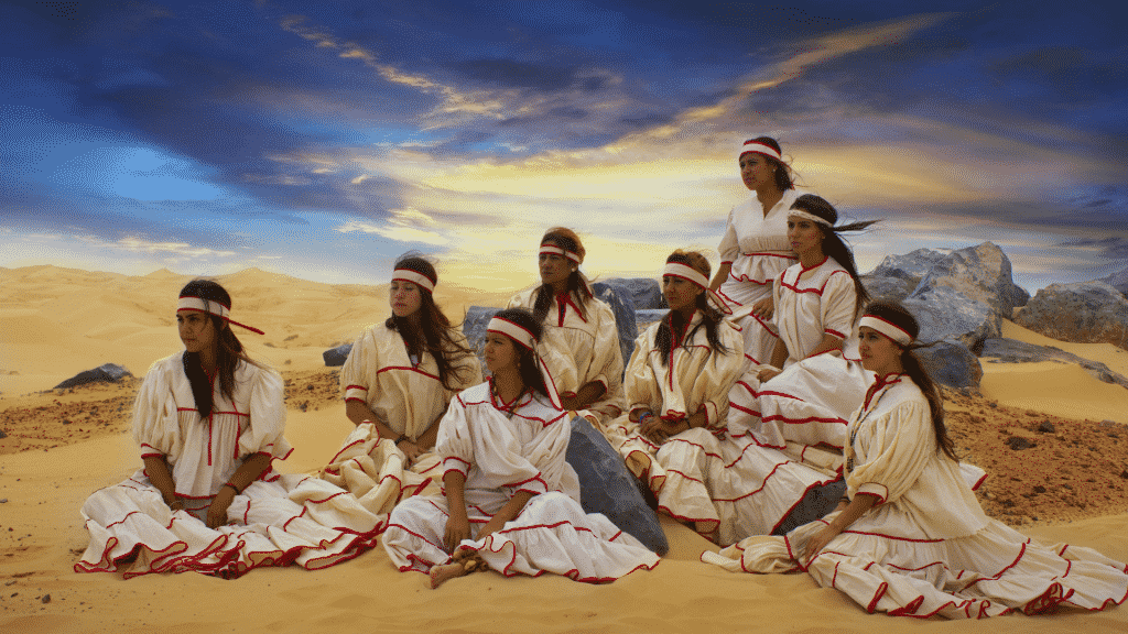 Mulheres com vestes indígenas no meio do deserto