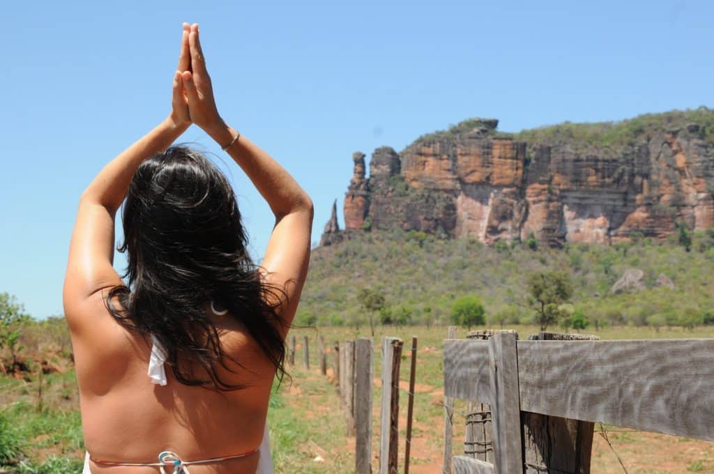 Mulher de costas em uma paisagem de montanhas.