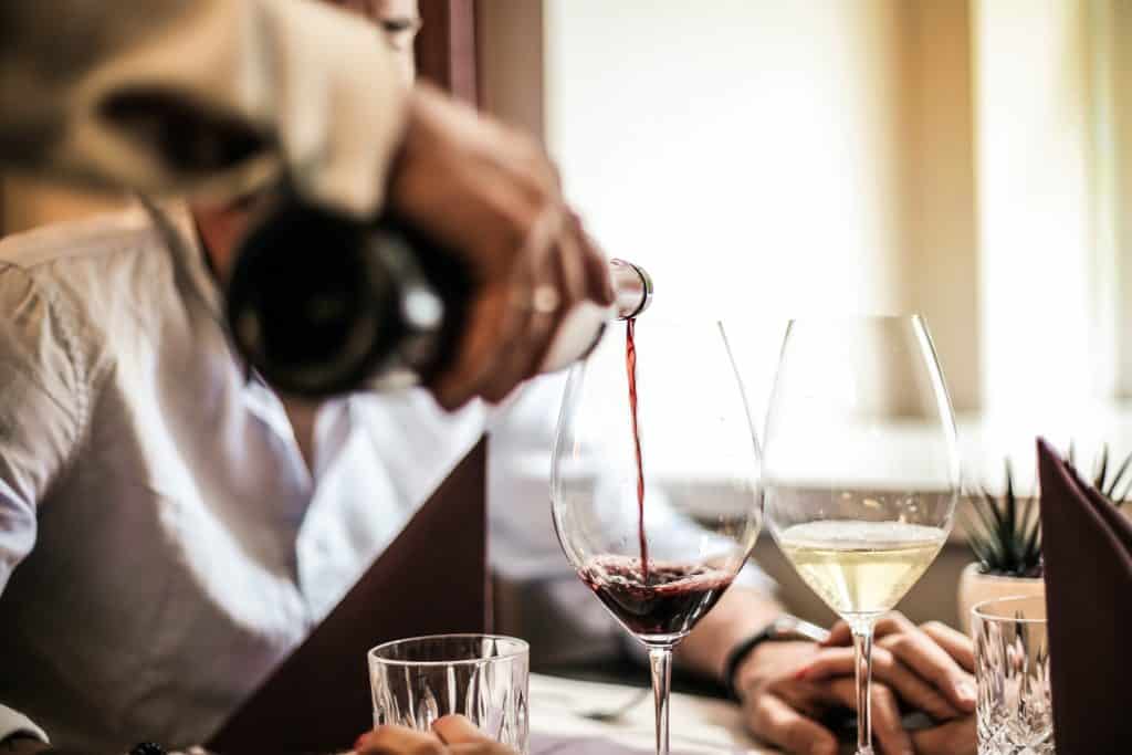 Garçom servindo vinho para um homem