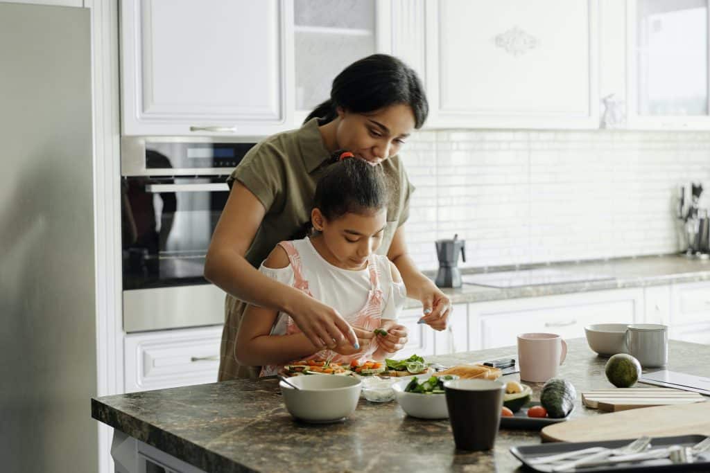 Mãe e filha cozinhando juntas