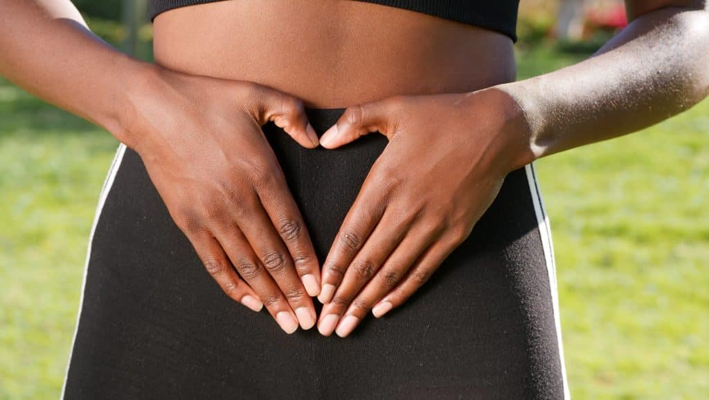 Mulher fazendo um coração comas mãos em frente à sua barriga