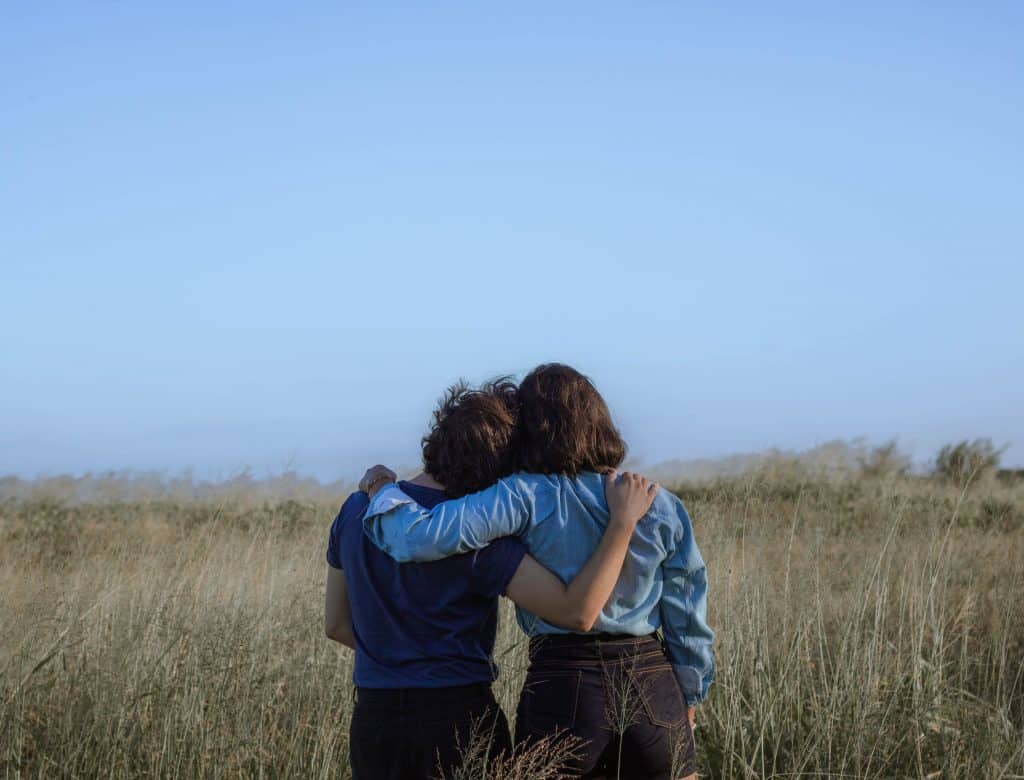 Um casal abraçado em um campo