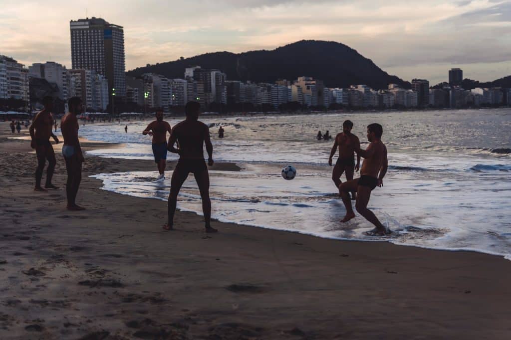 Homens jogando bola em uma praia do Rio de Janeiro.