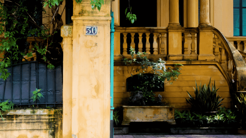 Foto da fachada de uma casa de muro amarelo