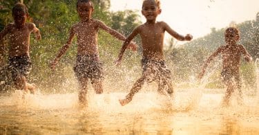 Meninos brincando em um lago.