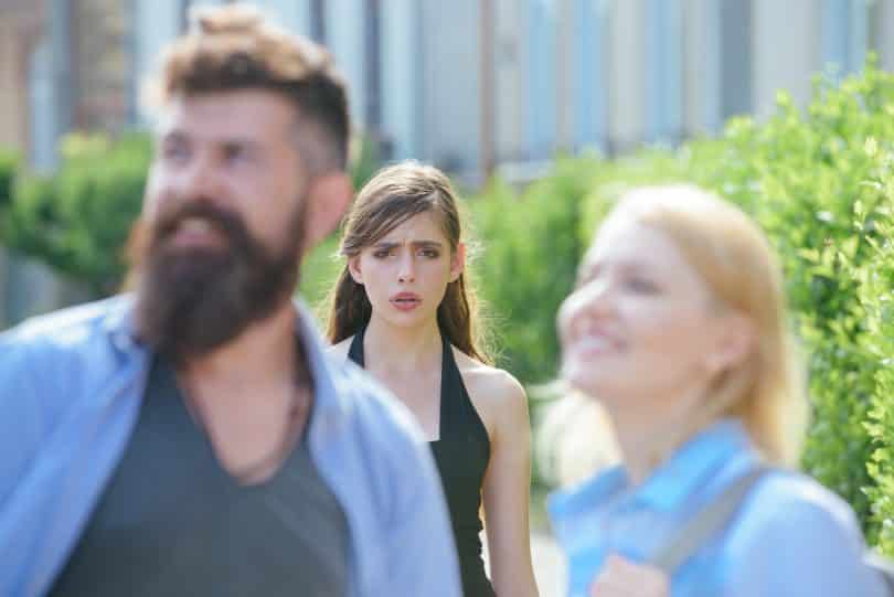 Mulher observando seu namorado em um encontro com outra mulher.