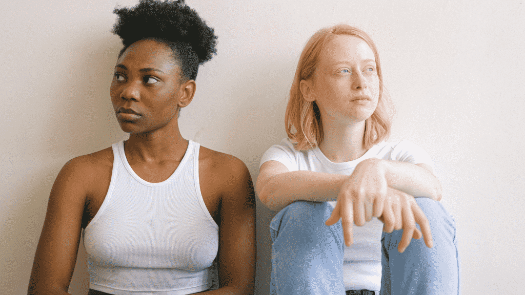 Mulheres sentadas no chão brigadas