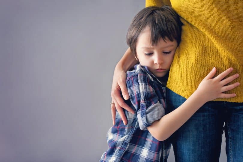 Menino abraçando a mãe.