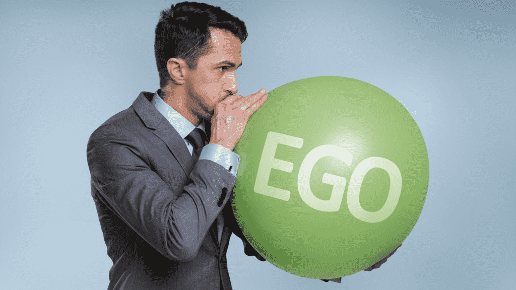 Homem enchendo balão de ar, onde está escrito "ego"