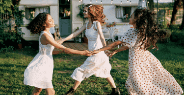 Mulheres sorrindo e dançando em círculo