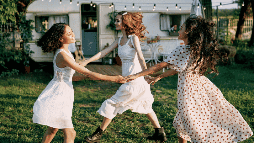 Mulheres sorrindo e dançando em círculo