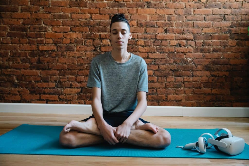 Garoto sentado meditando.