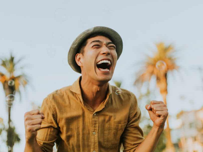 Homem branco de chapéu sorrindo.