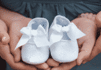 Pais segurando sapato de bebê