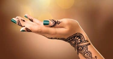 Mão de uma mulher com tatuagem mehndi.