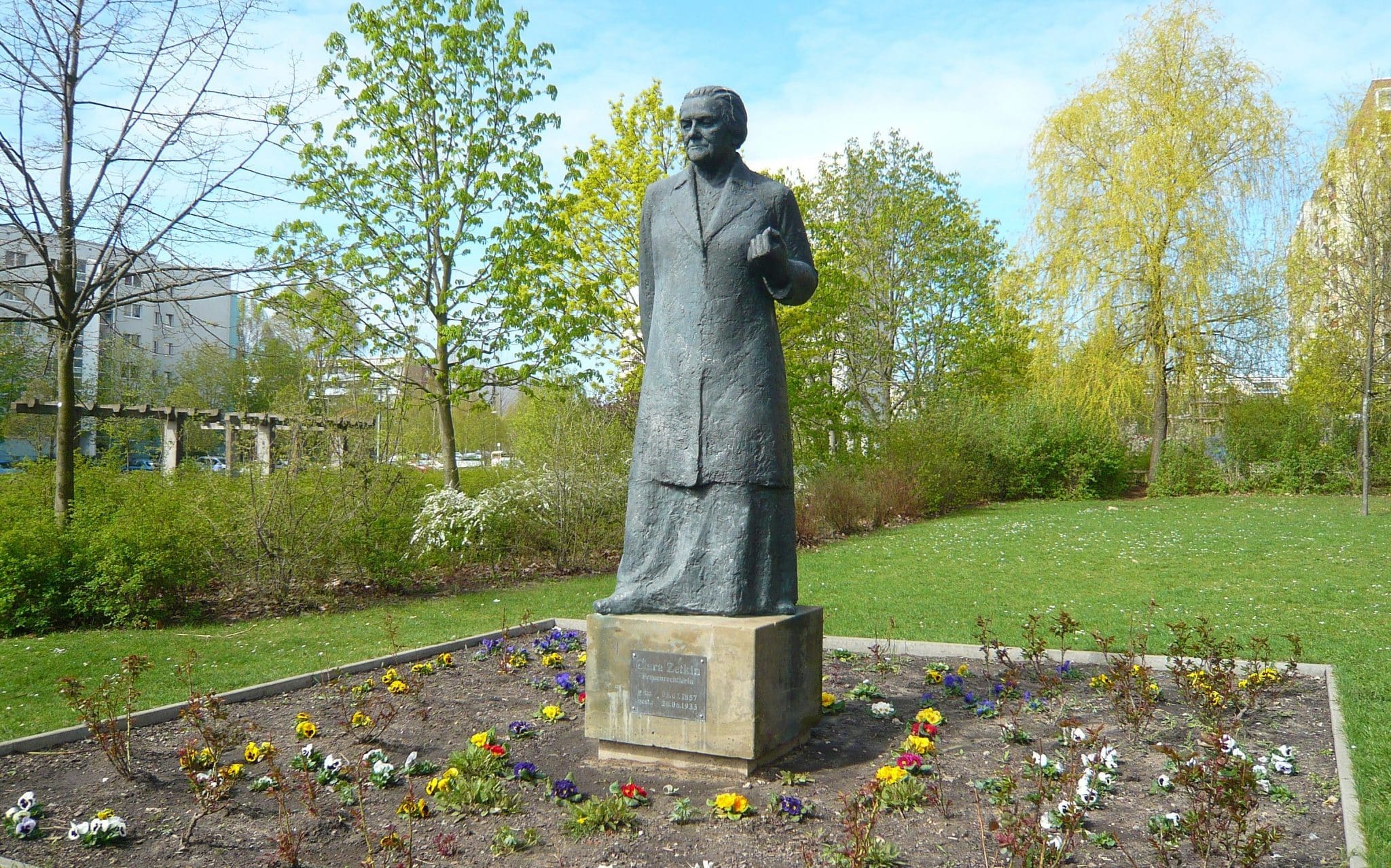 Estátua da ativista Clara Zetkin no meio de um jardim.