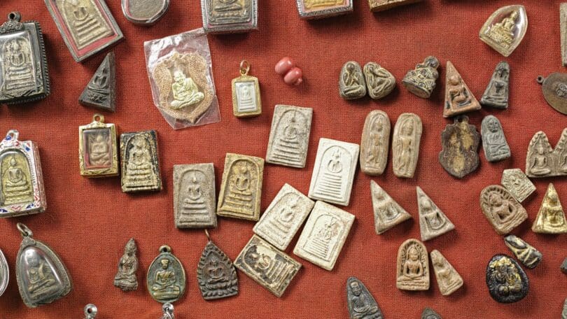Vários amuletos em cima de uma mesa vermelha
