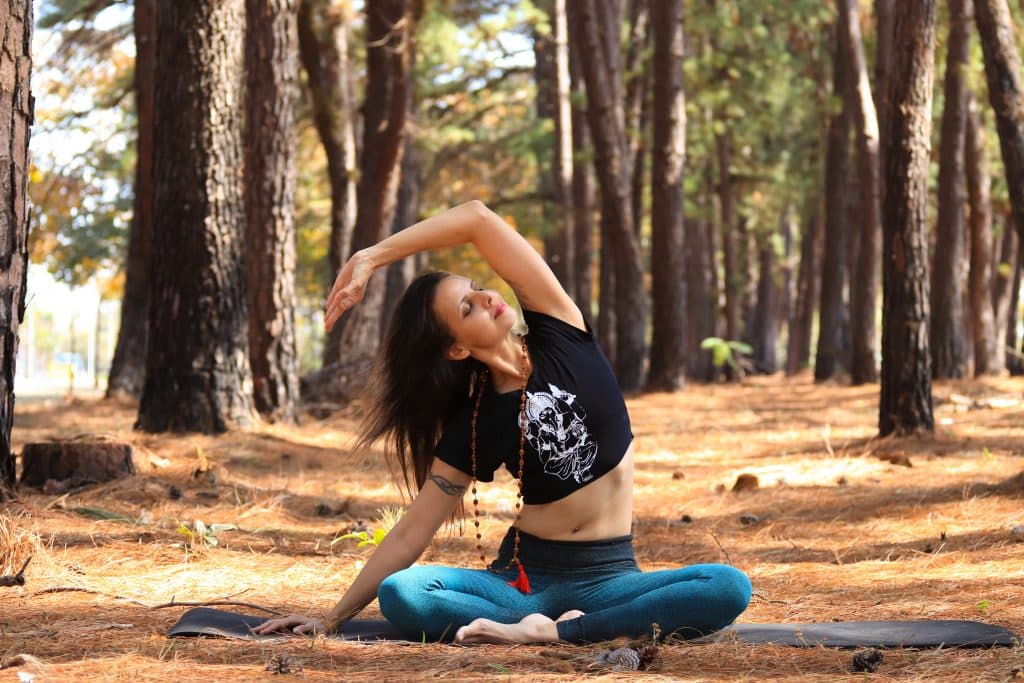 Mulher fazendo Yoga em uma floresta.