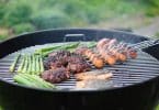 Linguiças e carne: um churrasco sendo feita numa churrasqueira.