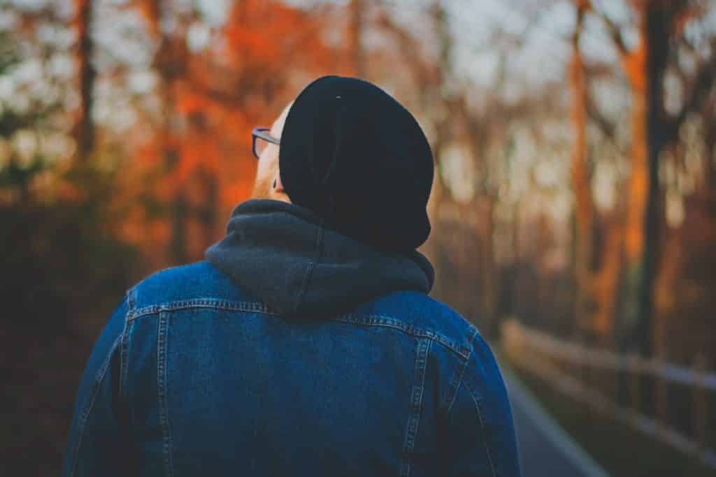 Homem branco com roupas de frio olhando para cima.