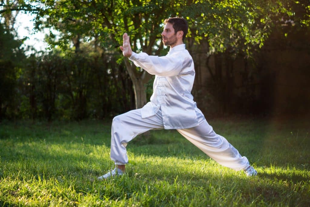 Um homem realizando um movimento de tai ji quan/tai chi chuan.