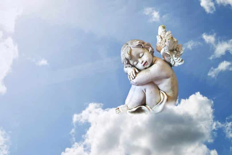 Uma escultura de um anjo dormindo numa nuvem.