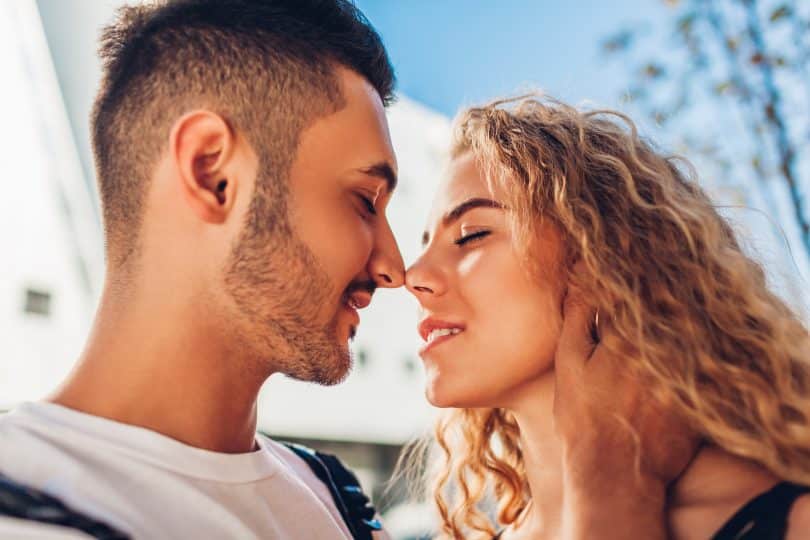 Um homem branco e uma mulher branca flertando.