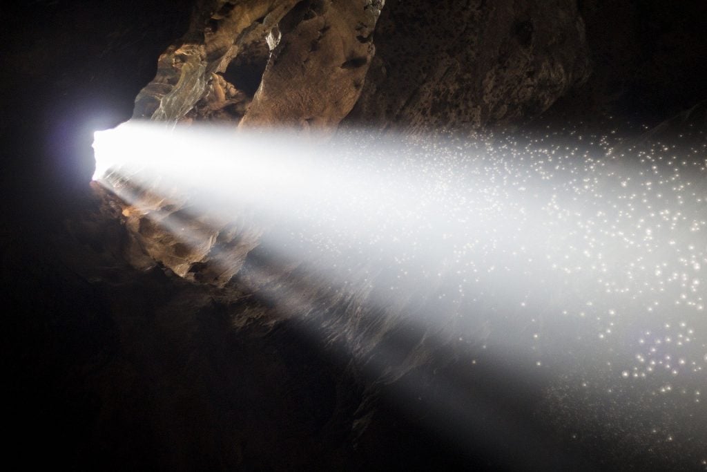 Uma gruta/caverna com um feixe de luz iluminado.