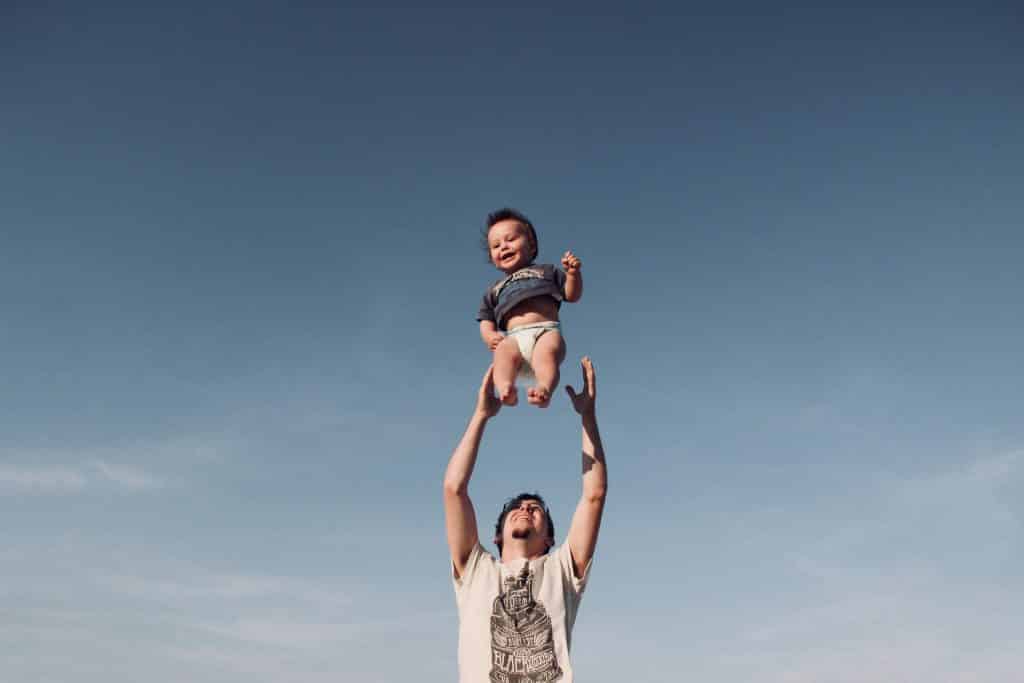 Pai jogando o seu bebê para o alto