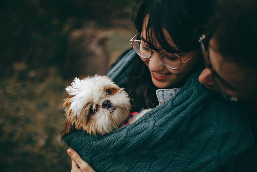 Casal abraçando um cachorrinho