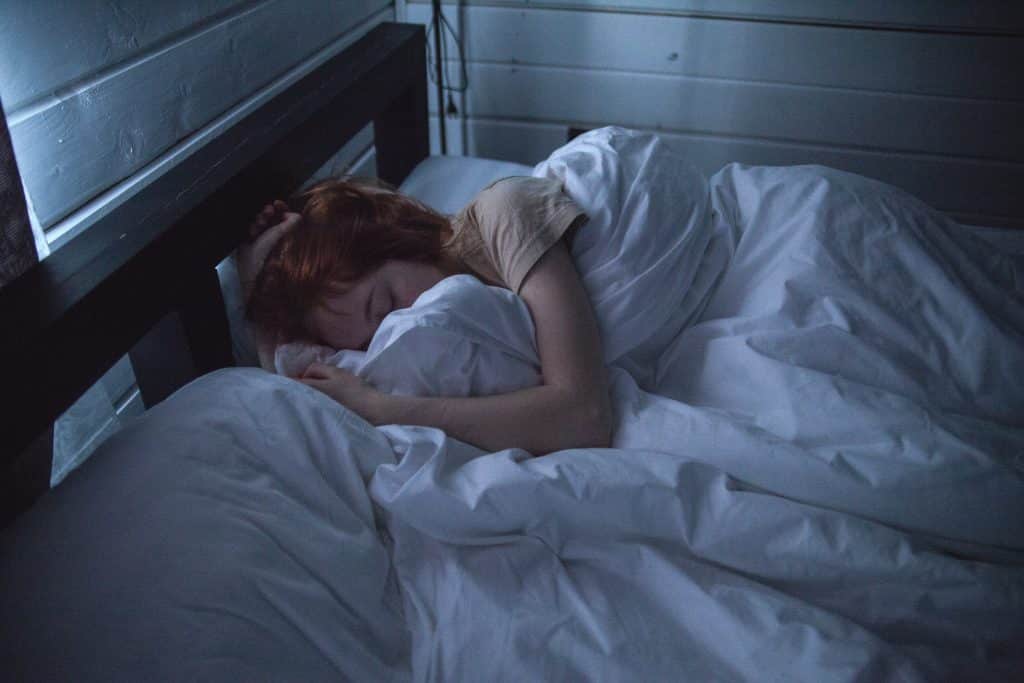 Mulher dormindo em sua cama durante a noite 