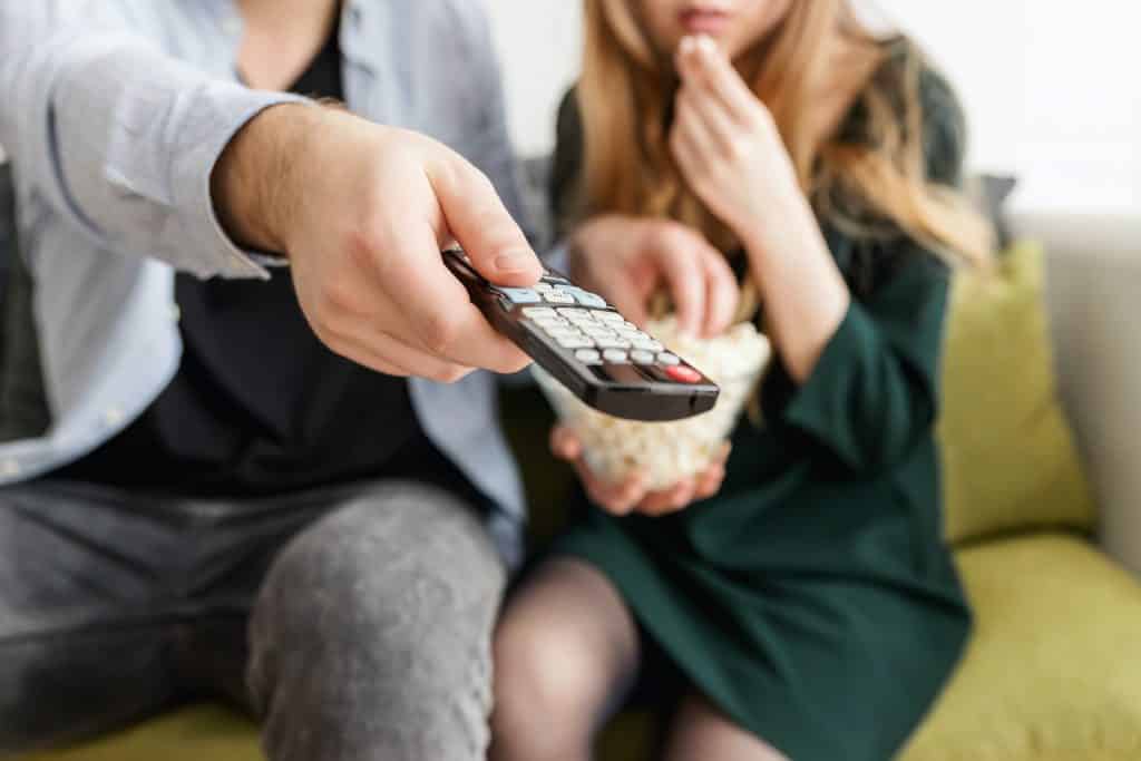 Homem segurando um controle para dar play em um filme