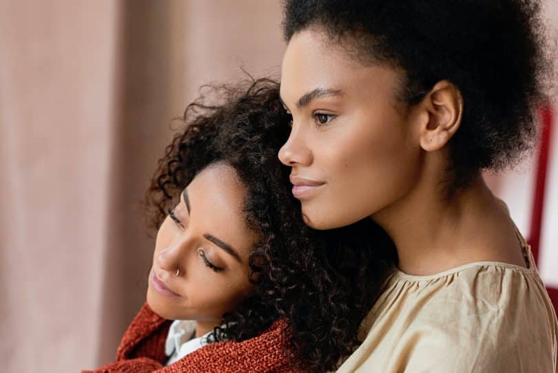 Mulheres negras com as cabeças encostadas.