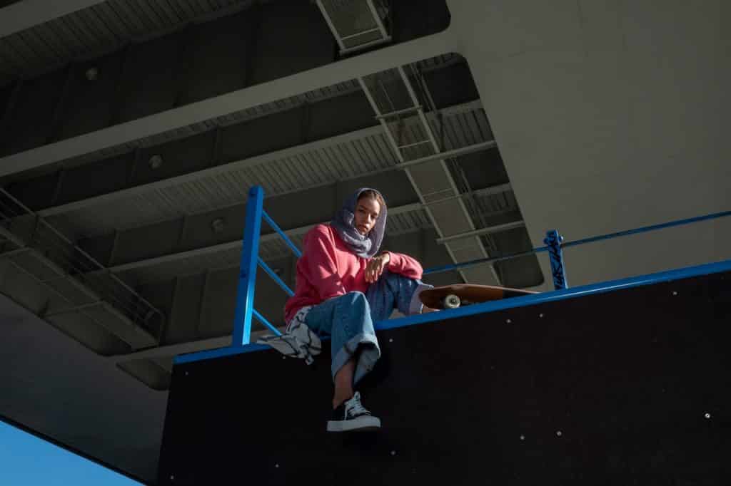 Mulher sentada em uma pista de skate.