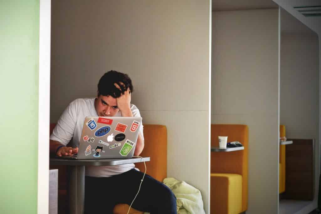 Homem estressado de frente para seu computador