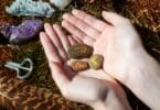 Mão segurando várias pedras com runas
