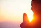 Um homem asiático meditando no pôr-do-sol