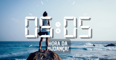 Hora igual 05:05 e texto "Hora da mudança!" aplicado por cima de foto de uma mulher em pé, em cima de uma rocha e de frente para o mar. Ao fundo, há o mar, o céu e o horizonte, os quais ela contempla.