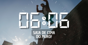 Hora igual 06:06 e texto "Saia de cima do muro!" aplicado por cima de foto de um homem pulando um muro de tijolos. Ao fundo, há um céu azul e a luz do sol.
