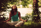 Mulher meditando sentada na grama