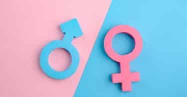 Sinais de gênero masculino e feminino em fundo azul e rosa.