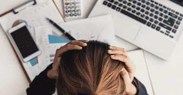 Mulher estressada no escritório com as mãos na cabeça