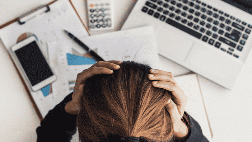 Mulher estressada no escritório com as mãos na cabeça