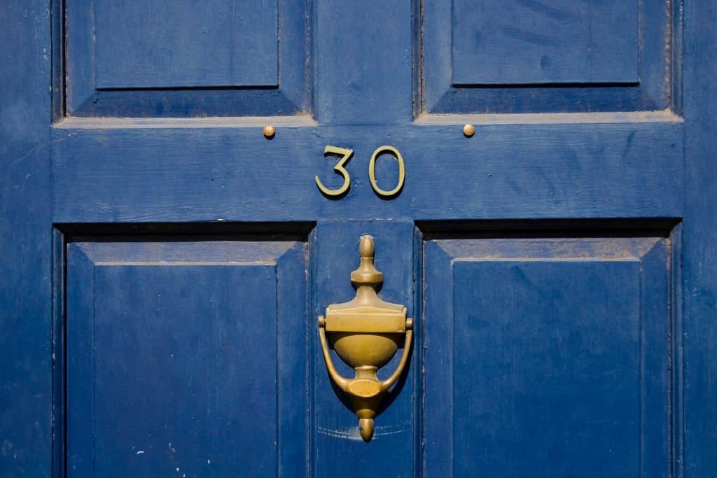 Porta azul com o número 30 em bronze.
