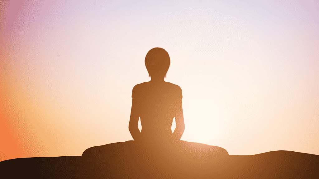 Silhueta de pessoa meditando no pôr do sol