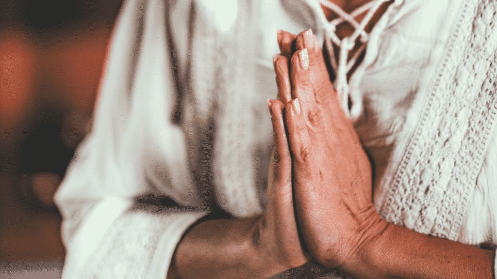 Imagem de mãos femininas juntas, em sinal de oração