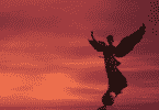 Silhueta da estátua de um anjo na frente do céu quase escurecendo